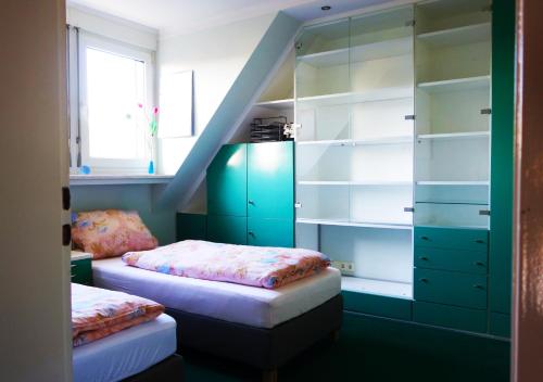 a bedroom with two beds and a staircase at Aparthotel Messe Flughafen in Düsseldorf
