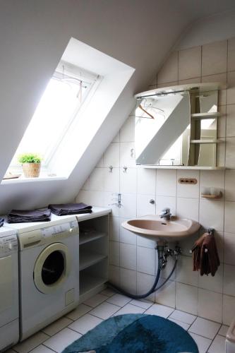a bathroom with a sink and a washing machine at Aparthotel Messe Flughafen in Düsseldorf
