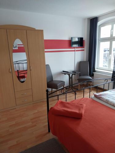 a hotel room with a bed and a table and chairs at Tangermünde Zum S c h m u c k Giebel - Pension & FeWo in Tangermünde