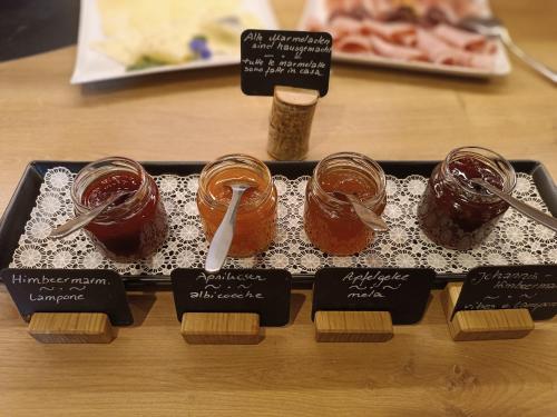 a tray with four jars of food on a table at Bed and Breakfast Ederhof in San Giacomo