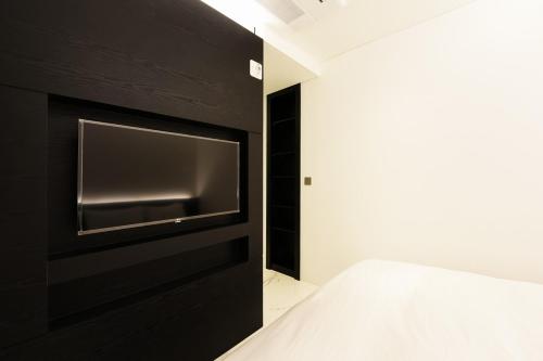 a bedroom with a black wall with a flat screen tv at Hotel Infini in Seoul