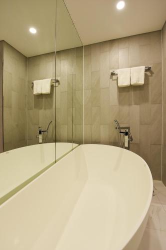 a bathroom with a tub and a glass shower at Hotel Infini in Seoul