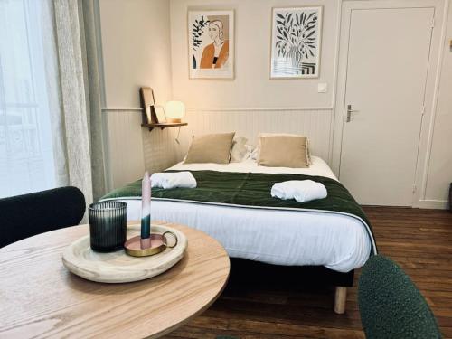 - une chambre avec un lit et une table avec une bougie dans l'établissement L'Oréva, adorable studio Rennes, à Rennes