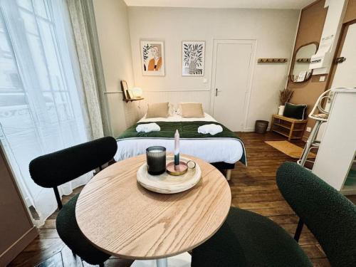 Cette petite chambre comprend une table et un lit. dans l'établissement L'Oréva, adorable studio Rennes, à Rennes