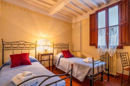 een slaapkamer met twee bedden en een raam bij Sweet Tuscany I Due Gigli in Arezzo