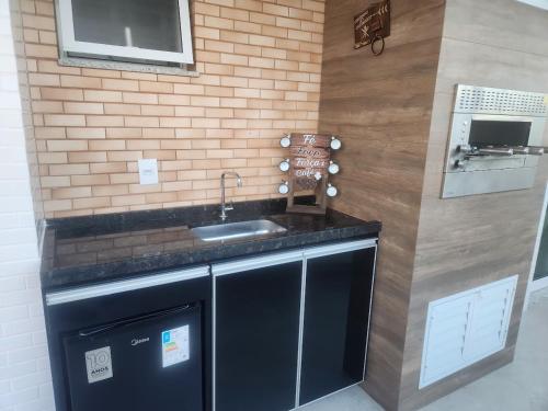 a kitchen with a sink and a brick wall at Apto frente mar 3 suites Castelhanos ES in Anchieta