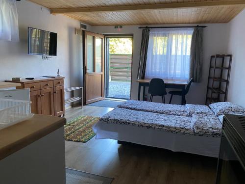 a bedroom with a bed and a desk and a kitchen at Skh 3 in Praid