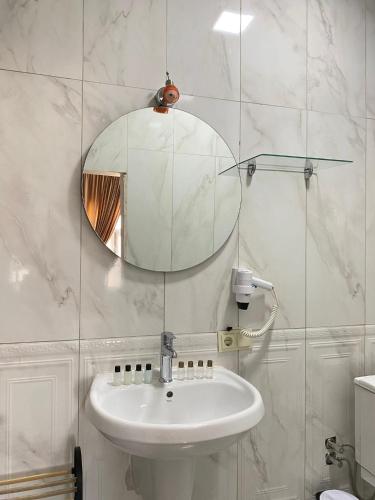 a white bathroom with a sink and a mirror at Şems inn hotel in Mardin