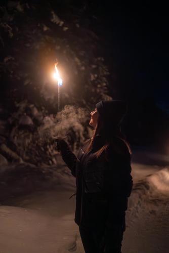 a woman standing on a street at night at Alpinhotel Berghaus spa in Tux
