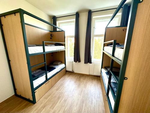 a room with three bunk beds and a window at Onefam Arbes in Prague