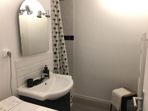 une salle de bain blanche avec un lavabo et un miroir dans l'établissement Charmant appartement au panier 2EM, à Marseille