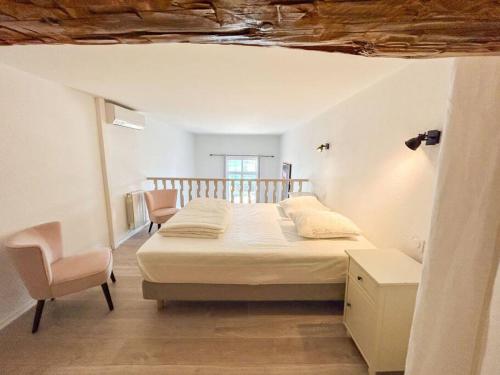 une chambre avec un grand lit et une chaise dans l'établissement Duplex port de Sanary - Vue mer, à Sanary-sur-Mer