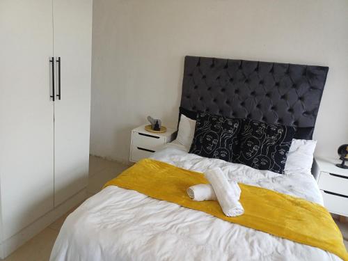 a bedroom with a large bed with a yellow blanket at On 36 Neethlingshof in Cape Town