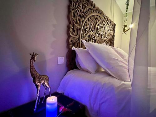 a bedroom with a bed with a giraffe statue on a table at NÜ-DE GITES ET SPA in Zuydcoote