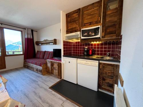 une cuisine avec un évier et un canapé dans une chambre dans l'établissement Résidence Grand Bois A916 Clés Blanches, à Courchevel