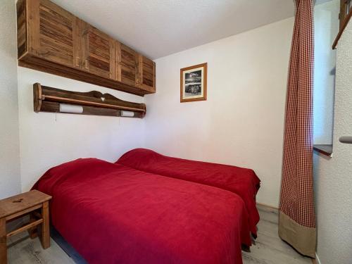 a bedroom with a red bed in a room at Résidence Grand Bois A916 Clés Blanches in Courchevel