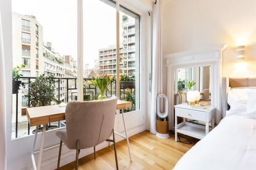 une chambre avec un lit et un bureau et un balcon dans l'établissement Maison Josephine Stunning Apartment Champs-Elysees 3 bedrooms, à Paris