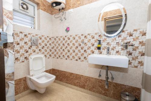 a bathroom with a toilet and a sink and a mirror at Lakeside Suites in Kolkata