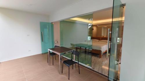 a dining room with a table and chairs and a bed at Mon Tresor มง เทร ซอ in Amphoe Sawang Daen Din