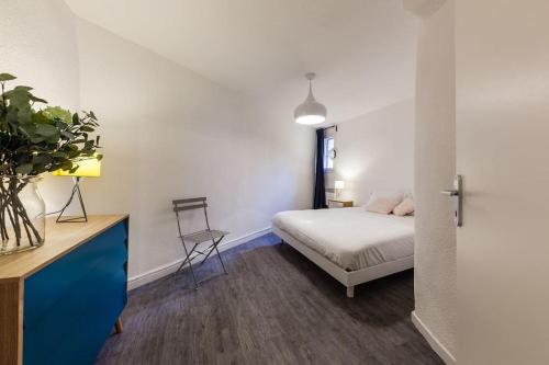 une chambre avec un lit et un bureau avec une chaise dans l'établissement Élégant Appartement au Panier 3EM, à Marseille