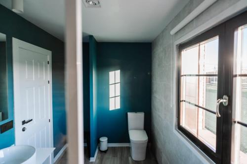 a bathroom with a toilet and a window at Camino Blanco in Ibeas de Juarros