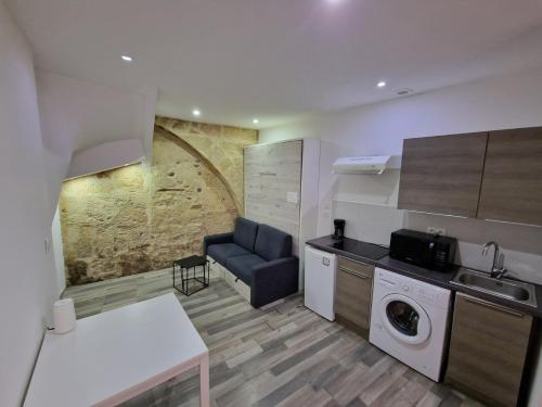 une cuisine avec un canapé, un évier et un lave-linge dans l'établissement Studio Fontaine Musicale, à Béziers