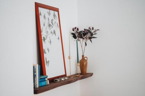 a mirror on a shelf with a vase with flowers at Holiday House Aguacate 2 in San Sebastián de la Gomera