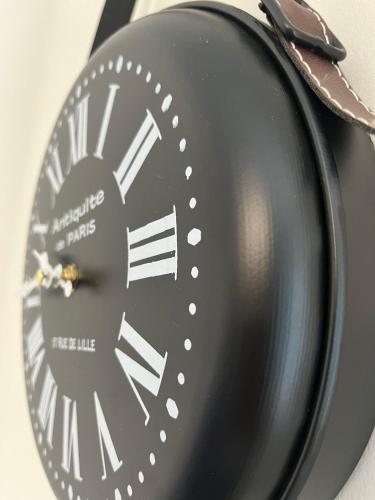 a black clock sitting on top of a table at Donna di Coppe Apartment in Torre Boldone