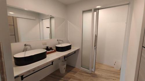 a bathroom with two sinks and a mirror at Mon Tresor มง เทร ซอ in Amphoe Sawang Daen Din