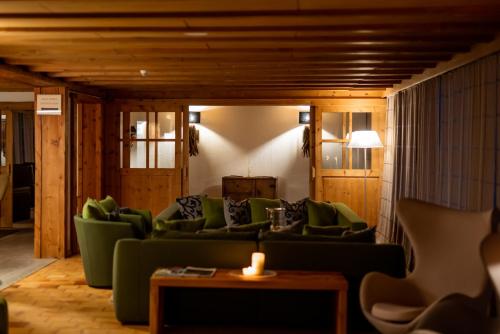 a living room with green couches and a table at Sporthotel Teresa in Badia