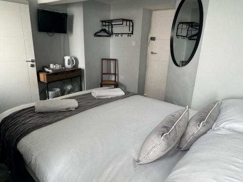 a bedroom with a bed with two pillows and a mirror at Severn Valley Guest House in Bewdley