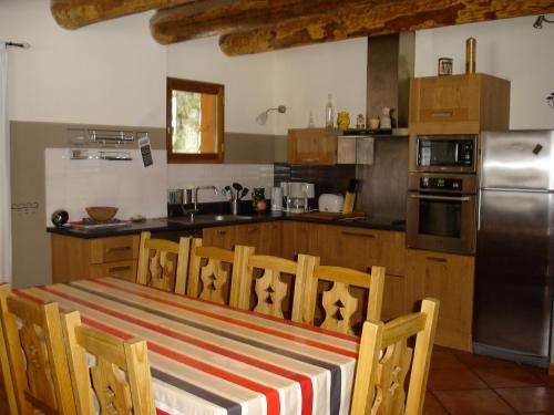 une cuisine avec une table et un tissu de table rayé dans l'établissement Grand chalet proche St Lary Soulan - tout inclus wifi linge et ménage, à Aragnouet