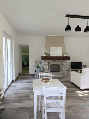 - un salon avec une table blanche et une cheminée dans l'établissement La passerelle ,Montreuil ,Le Mans, à Neuville-sur-Sarthe