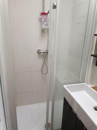 une salle de bain blanche avec une douche et un lavabo dans l'établissement Home Sweet Home, à Aubervilliers