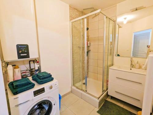 une machine à laver dans une salle de bain avec douche dans l'établissement Appartement équipé tout confort Montélimar, à Montélimar