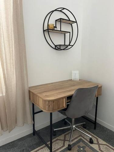 - un bureau avec une chaise et un miroir mural dans l'établissement Le cosy de la cité Foulc, à Nîmes
