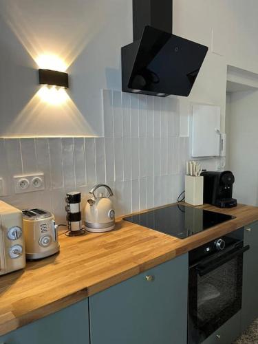 une cuisine avec un comptoir avec une cuisinière dans l'établissement Le cosy de la cité Foulc, à Nîmes