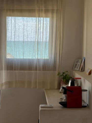 a kitchen counter with a window with the ocean at La Conchita Tulum in Tulum