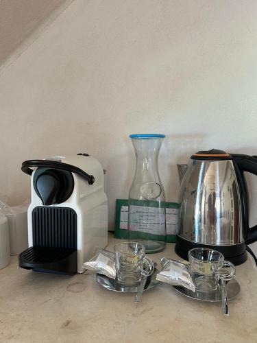 a counter with a coffee maker and a tea kettle at La Conchita Tulum in Tulum