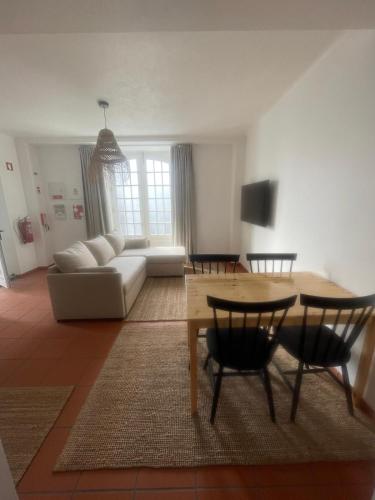 a living room with a table and a couch at Mar D'Abstração in Urzelina