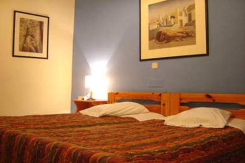 a bedroom with a large bed with a blue wall at Sun View Guesthouse in Delphi