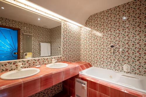 a bathroom with two sinks and a large mirror at Sporthotel Teresa in Badia