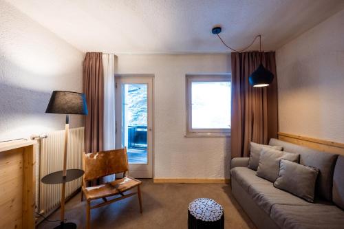 a living room with a couch and a table and a window at Sporthotel Teresa in Badia