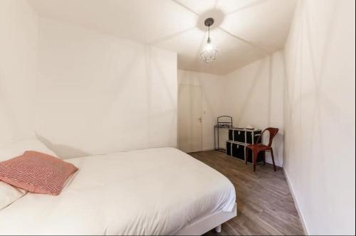 une chambre blanche avec un lit et un bureau dans l'établissement Charmant appartement au panier 1ER, à Marseille