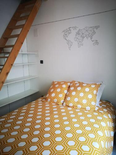 - une chambre dotée d'un lit avec un couvre-lit jaune et blanc dans l'établissement Cosy & calme, centre-ville, à Saint-Jean-dʼAngély