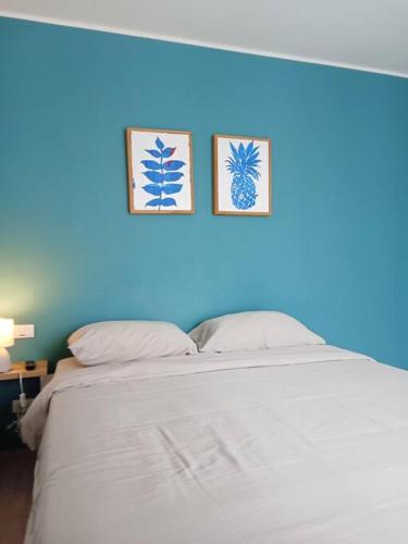 a blue wall with two pictures above a bed at Contemporary 1BR Condo - NV-724 in Phuket
