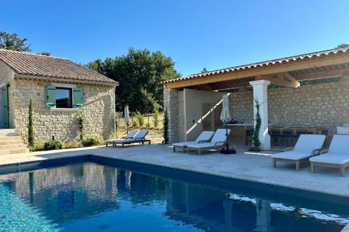 a patio with chairs and a swimming pool at LE Mas Jas magnificent Mas Provençal - Lauris in Lauris