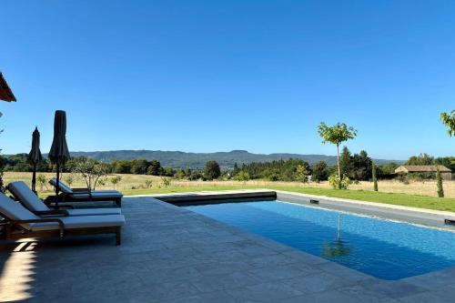 a swimming pool with two lounge chairs and a swimming pool at LE Mas Jas magnificent Mas Provençal - Lauris in Lauris