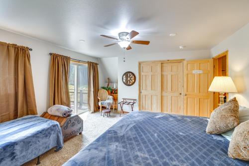 Un dormitorio con dos camas y un ventilador de techo. en Remote Elk City Escape with Decks and Mtn Views!, en Elk City
