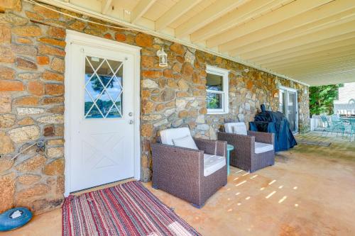 a stone house with two chairs and a white door at Smith Mountain Lake Retreat with Private Beach! in Huddleston